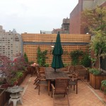 A terrace deck designed by All Decked Out NYC. Wood partition fence, custom planters, pots and garden containers with wooden patio furniture.